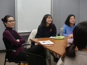 Faculty instructor and two students having a discussion at a group lab meeting